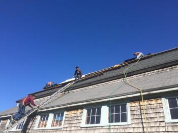 Jim Leahy of Readfield roofing firm Kasie-Jo Inc. climbs a ladder Oct. 15 as he and fellow crew members replace the south-facing roof of the 1800s, Morris Farm barn. The nonprofit farm on Wiscasset’s Gardiner Road was having the work done ahead of the installation of solar panels. SUSAN JOHNS/Wiscasset Newspaper Morris Farm, roof