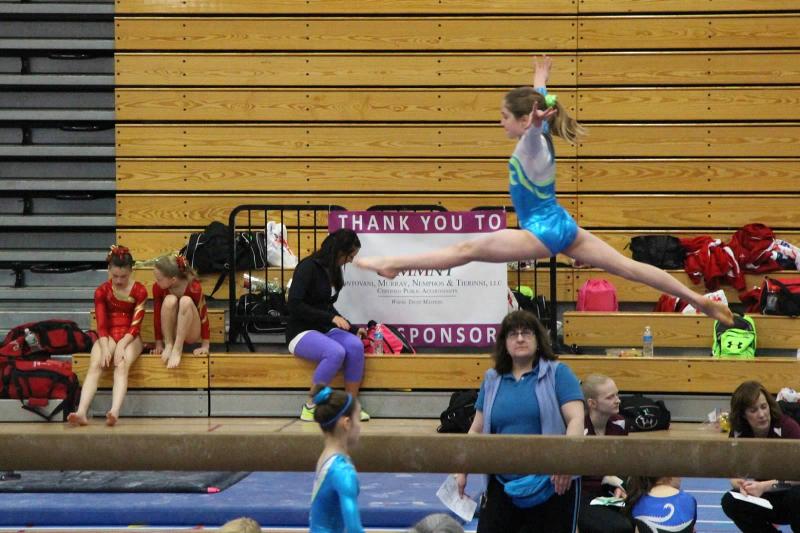 Maddy Russ, northeast regional champion performs a split leap on the balance beam. Courtesy of Liz Hall
