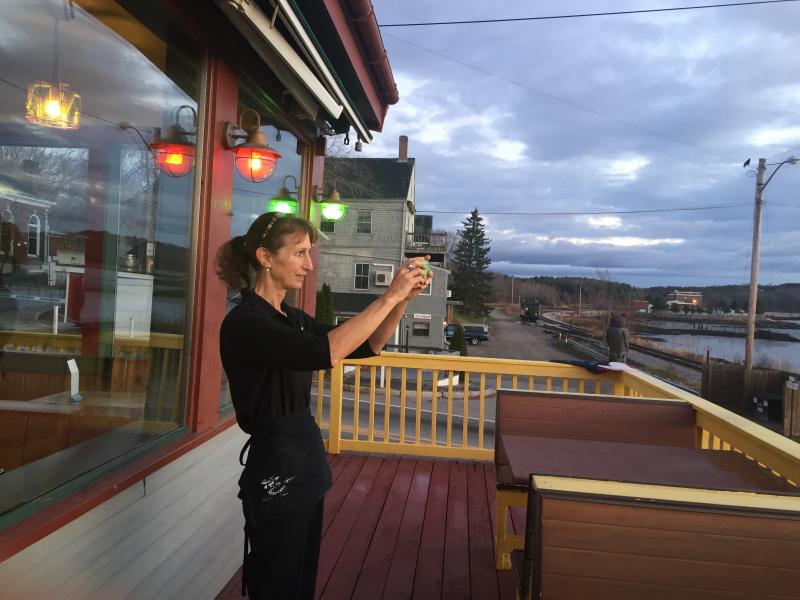 Outdoors at Sarah’s Cafe during the Wiscasset Early Bird Sale, Susan Robson takes a picture of the Nov. 14 sunrise over the Sheepscot River. SUSAN JOHNS/Wiscasset Newspaper