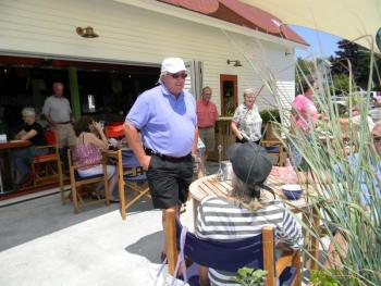 Oliver's proprieter Paul Coloumbe, center, greets customers on July 13 while he waits for his haddock taco to be served. At Oliver's, customers have three different choices for seating: on the dock, inside or upstairs on the porch. DIANE RANDLETT/Boothbay Register DIANE RANDLETT / Boothbay Register Paul Coloumbe Oliver's Cozy Harbor wharf