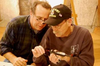 Veterans Camp volunteer Dr. Sean Moran, left, gives tips to a Vietnam veteran during the fly-tying workshop at camp. Courtesy of Joe Tatem