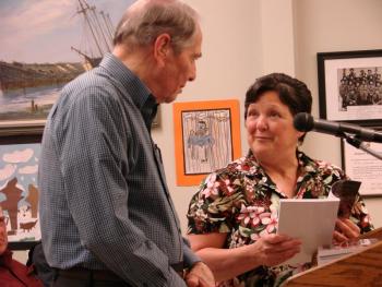 Longtime local realtor Roy Farmer, left, hears from Wiscasset's Board of Selectman Chairman Pam Dunning that this year's town report is dedicated to him. SUSAN JOHNS/Wiscasset Newspaper