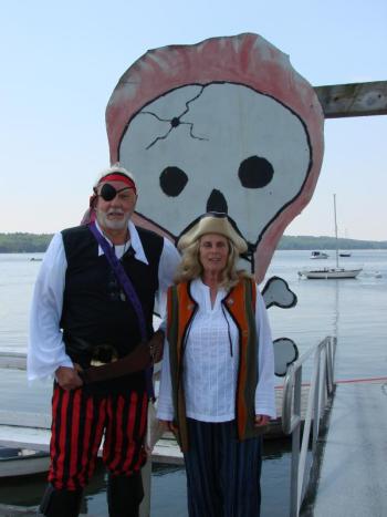 Alan and Judith Boyes try out their pirate gear ahead of Wiscasset's Fourth of July festivities. The harbor behind them, near the Wiscasset Yacht Club, will be the scene of a pirate attack, slated for 11:45 a.m. Thursday. SUSAN JOHNS/Wiscasset Newspaper