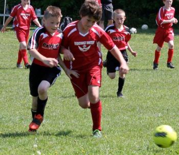 Grady Schur battles for the ball during the June 2 game against the Patriots at Clifford Playground, which ended in a 1-1 tie. Also pictured are Midcoast teammates Kaleb Ames, right, and Sam Sinibaldi, left. SUE MELLO/Boothbay Register