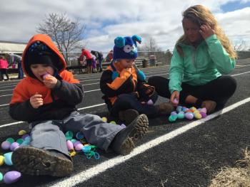 Jett Dowling, left, of Dresden bites a plastic egg as he and his twin brother Jaxx Dowling and cousin Danielle Kotow go over the eggs the boys collected March 26 at Wiscasset’s Easter egg hunt. SUSAN JOHNS/Wiscasset Newspaper