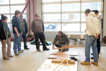 Steve Cayard demonstrates steaming and bending a canoe rib for a class of Lincoln Academy students. Cayard is the master boat builder in charge of the birch bark canoe currently under construction in LA's ATEC center. Courtesy of DRA