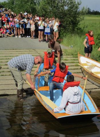 Maine Maritime Museum boatshop manager Kurt Spiridakis, left, and George Sprague lend a hand to Woolwich Central School students at the June 14 boat launch. PHIL DI VECE/Wiscasset Newspaper