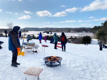 Volunteers tend to the fire and hot cocoa on the big hill at Salt Bay Farm during a Coastal Rivers pop-up sledding party. Courtesy photo 