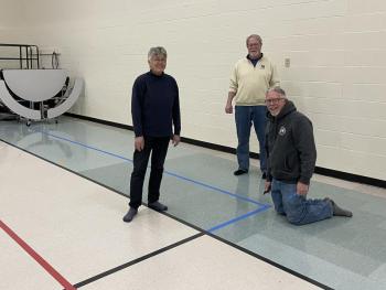 From left, Susan Hartford, Kipp Bacon and Randy Finamore (kneeling) help with a pickleball unit at Dresden Elementary School. Peter Walsh photo 